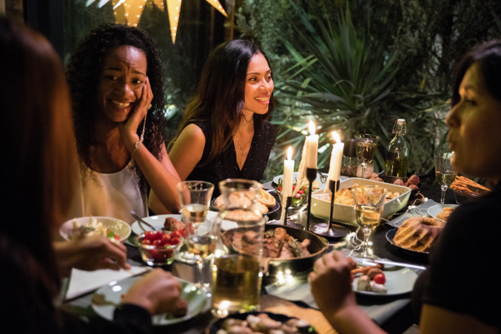 Groupe de femmes riant autour d'un dîner aux chandelles